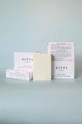 SITTI soap bars and packaging on a light blue surface with a light blue background