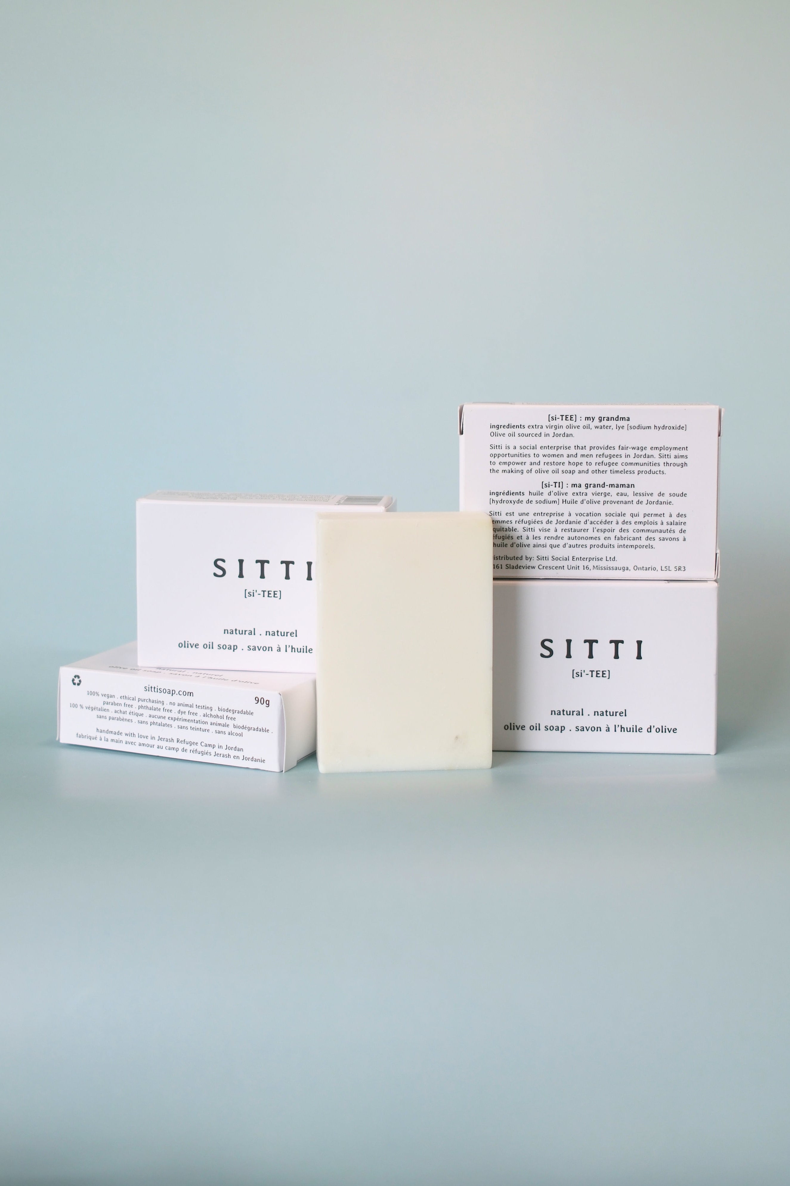 SITTI soap bars and packaging on a light blue surface with a light blue background