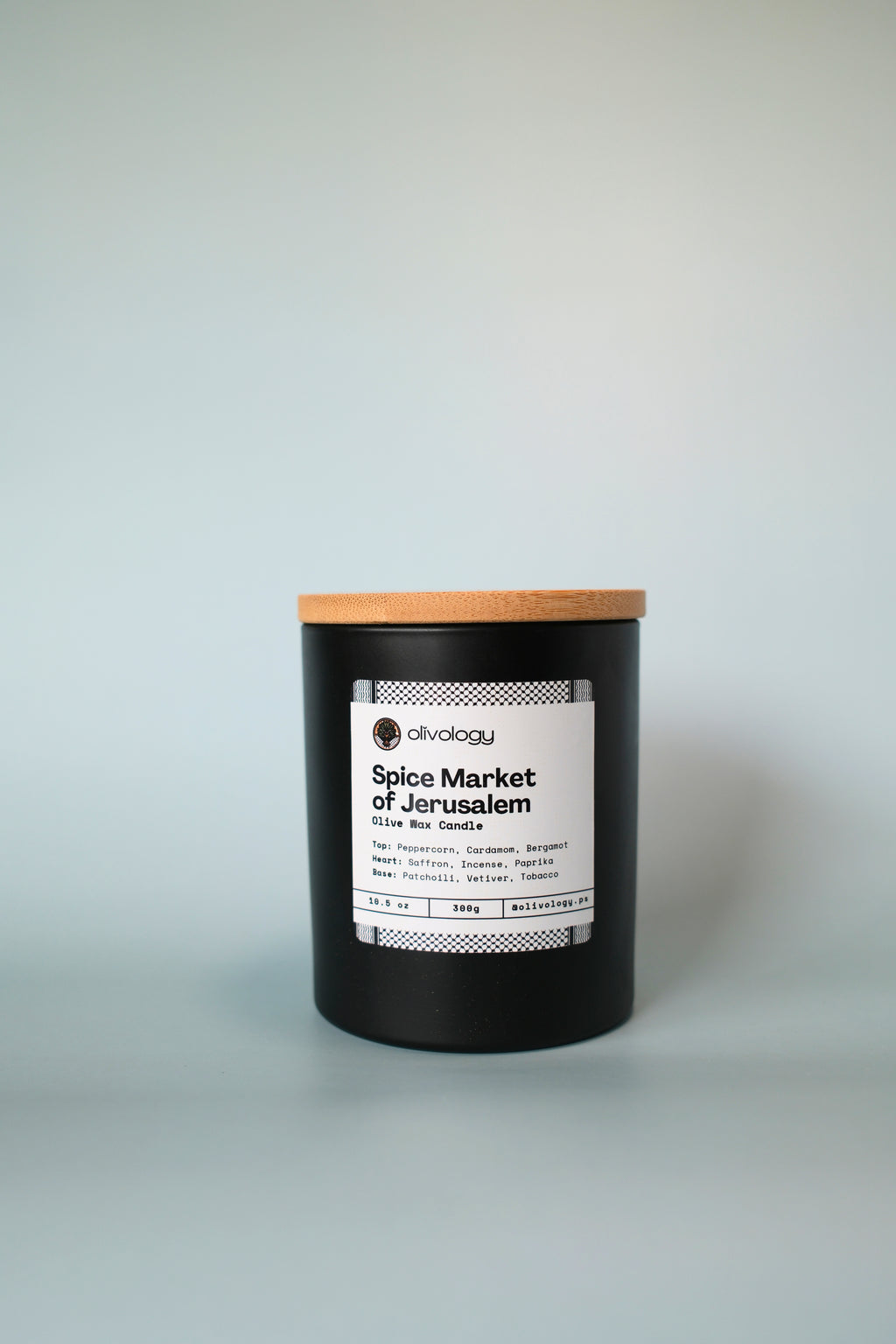 Candle with a wooden lid labeled 'Spice Market of Jerusalem' on a white background