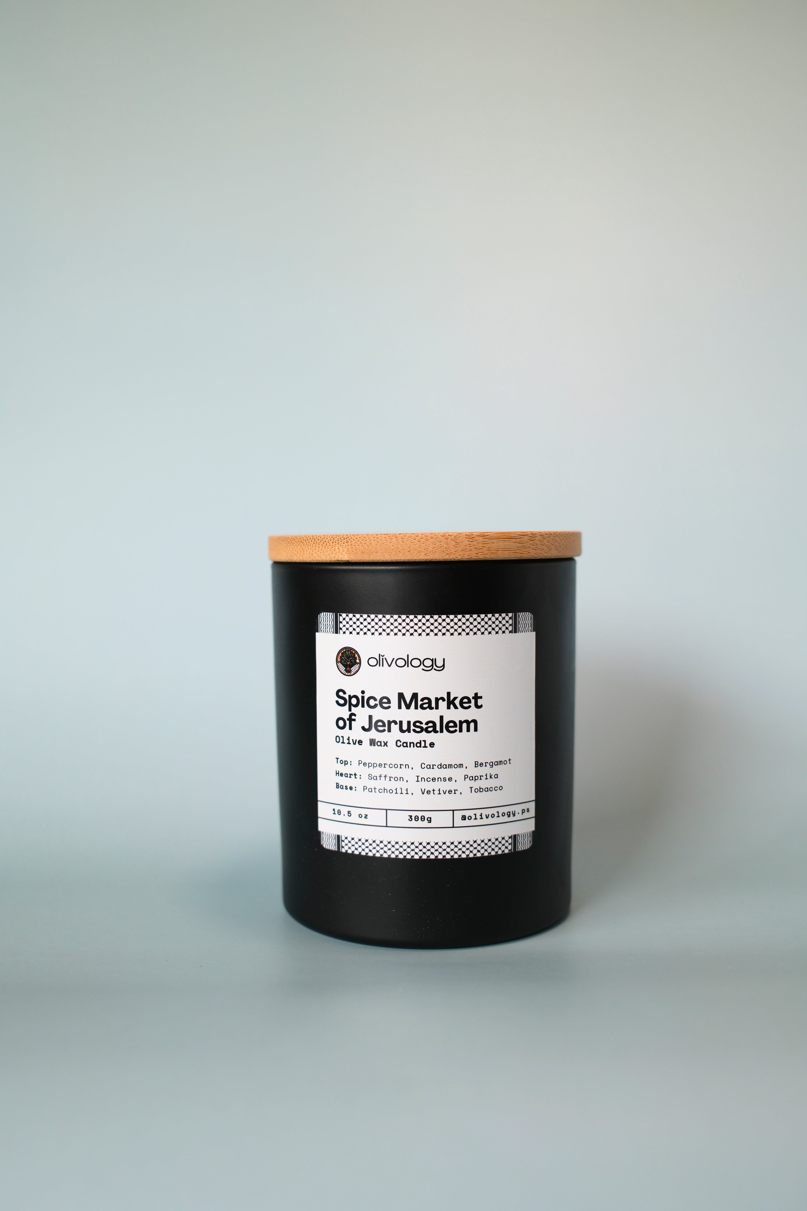 Candle with a wooden lid labeled 'Spice Market of Jerusalem' on a white background